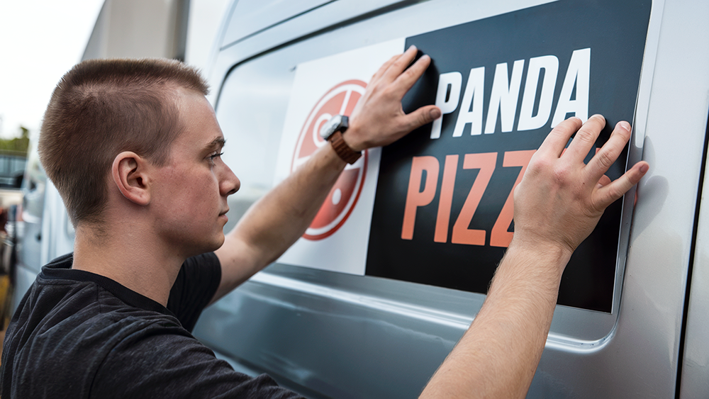 Araç magneti yüzeye uygulayan bir erkek